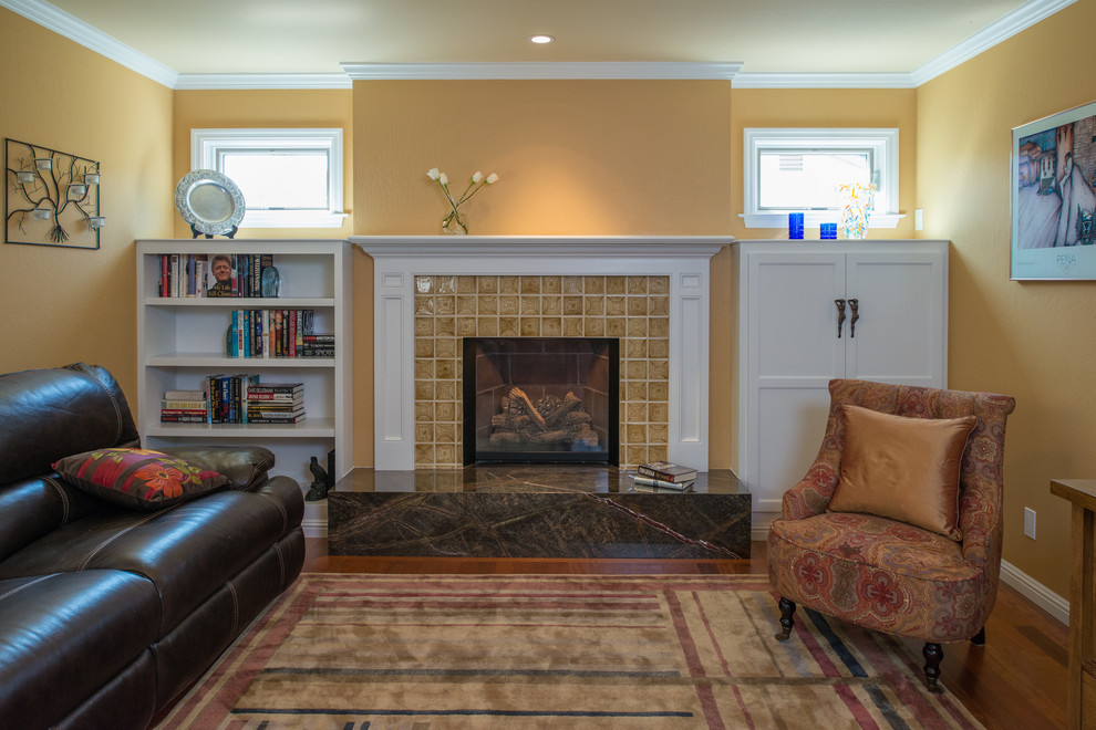 Family room - mid-sized traditional enclosed carpeted family room idea in San Francisco with yellow walls, a standard fireplace, a tile fireplace and no tv