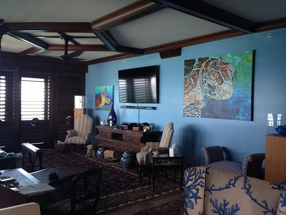 Aménagement d'une salle de séjour exotique fermée avec un mur bleu, parquet foncé et un téléviseur encastré.