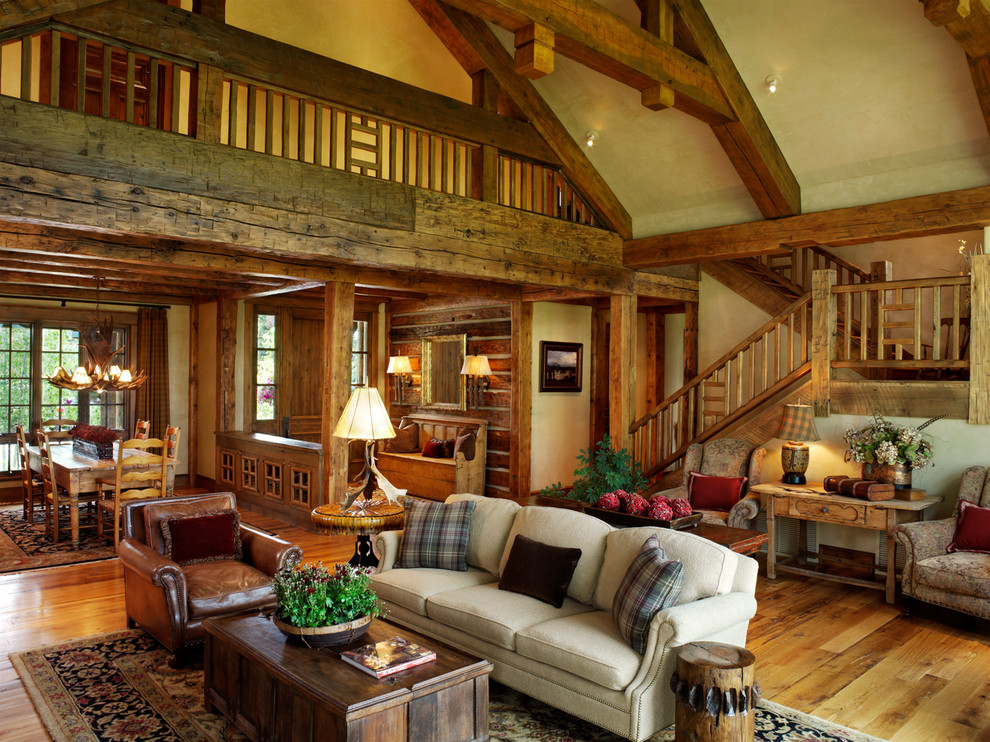 Imagen de sala de estar abierta, rural, extra grande, con paredes beige, suelo de madera en tonos medios y suelo multicolor