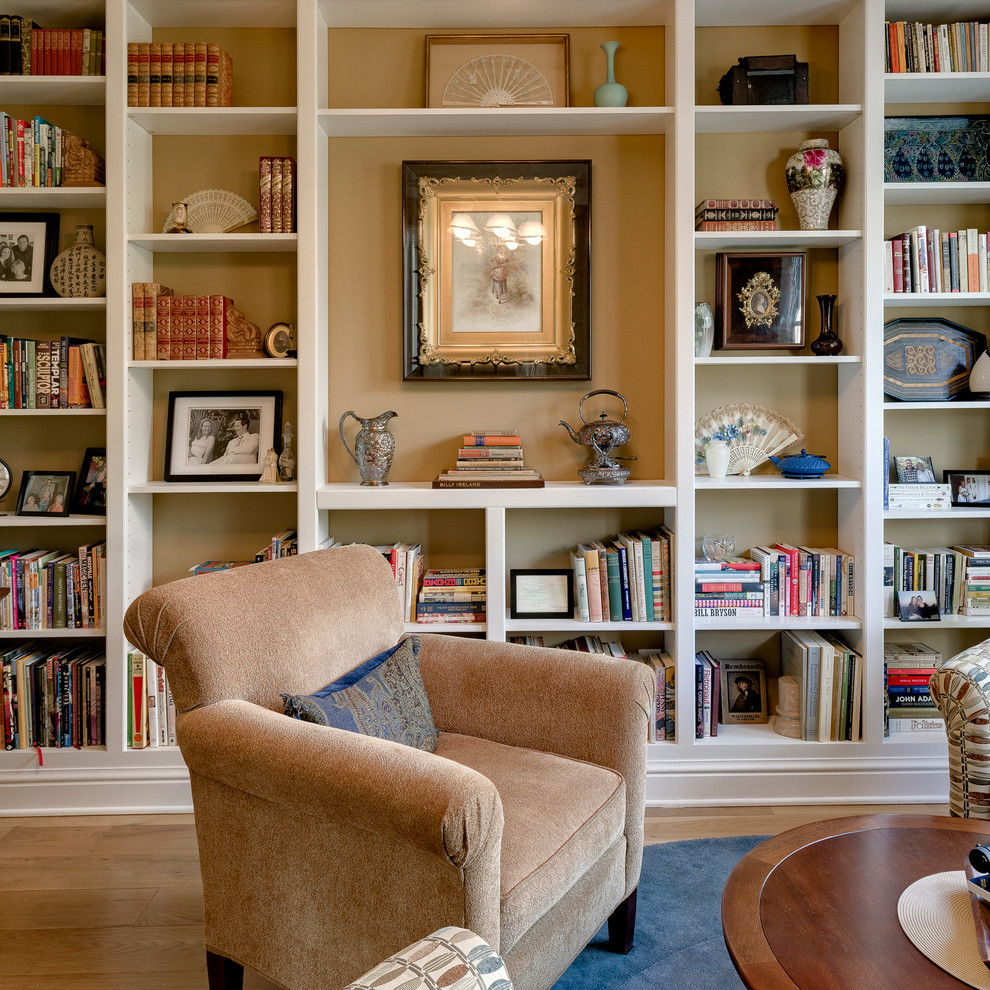 Example of a mid-sized transitional open concept light wood floor family room library design in Columbus with beige walls, no fireplace and no tv