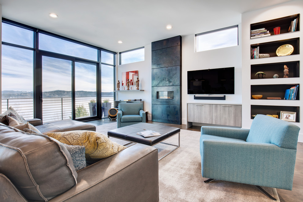 Modelo de sala de estar con biblioteca abierta contemporánea grande con marco de chimenea de metal, paredes blancas, chimenea lineal, televisor colgado en la pared y alfombra