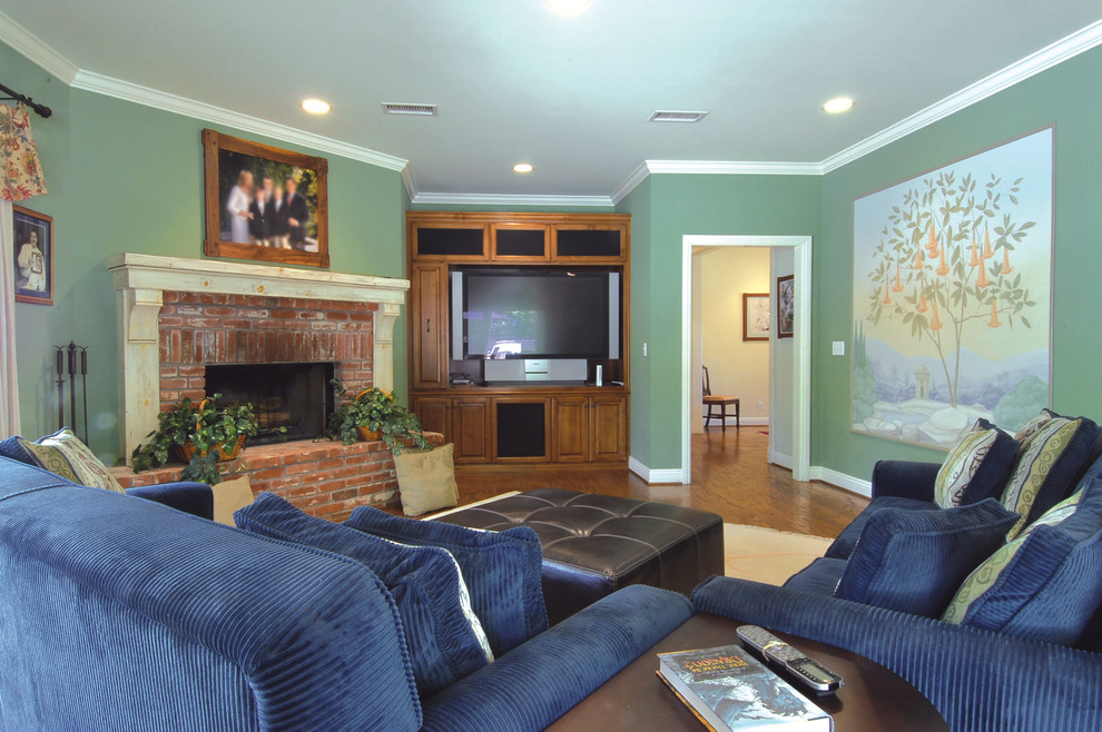 Immagine di un soggiorno classico di medie dimensioni e chiuso con pareti verdi, parquet chiaro, camino classico, cornice del camino in mattoni e parete attrezzata
