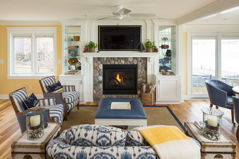 Inspiration for a nautical open plan games room in Minneapolis with yellow walls, medium hardwood flooring, a standard fireplace, a stone fireplace surround and a wall mounted tv.