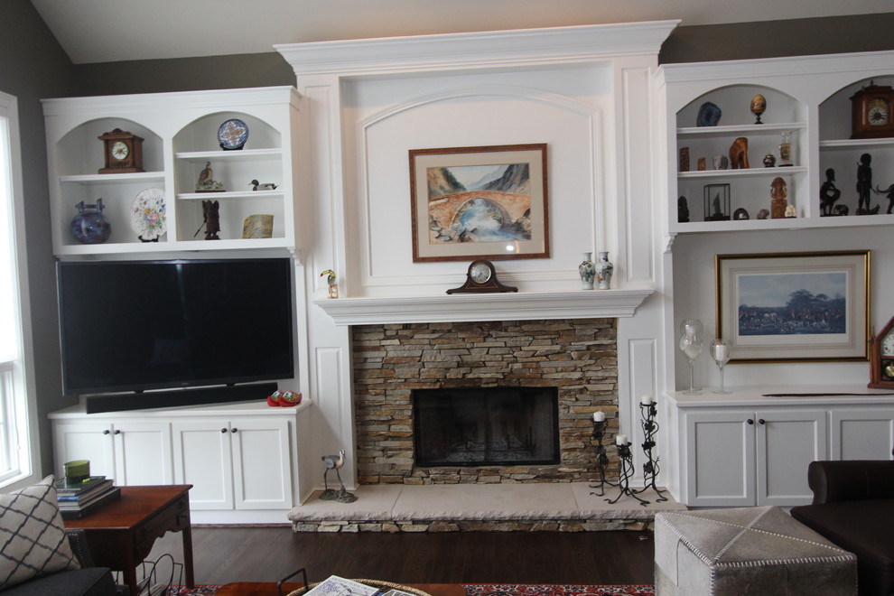 Mittelgroßes, Offenes Klassisches Wohnzimmer mit braunem Holzboden, Kamin, Kaminumrandung aus Stein, TV-Wand und grauer Wandfarbe in Cincinnati