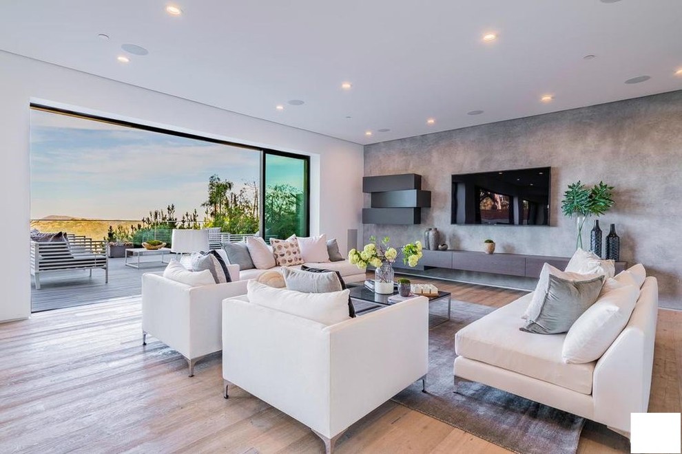 Immagine di un grande soggiorno minimalista aperto con sala della musica, pareti grigie, pavimento in bambù, TV a parete e pavimento beige