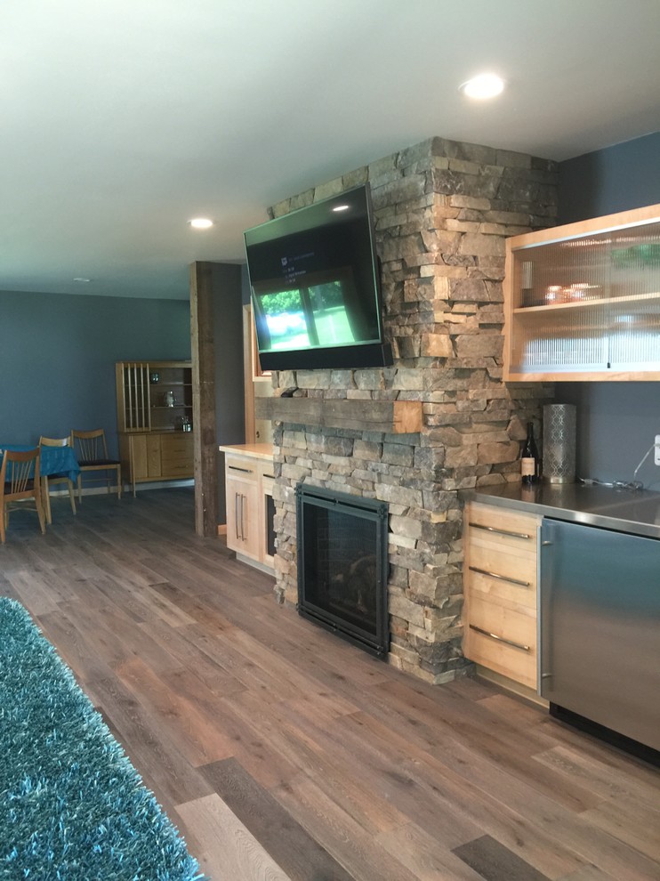 Large country open plan games room in Other with blue walls, light hardwood flooring, a standard fireplace, a metal fireplace surround and a wall mounted tv.
