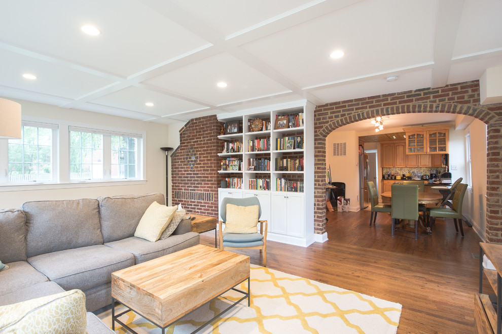 Foto di un soggiorno minimalista di medie dimensioni e chiuso con libreria, pareti beige, pavimento in legno massello medio, TV autoportante e pavimento marrone