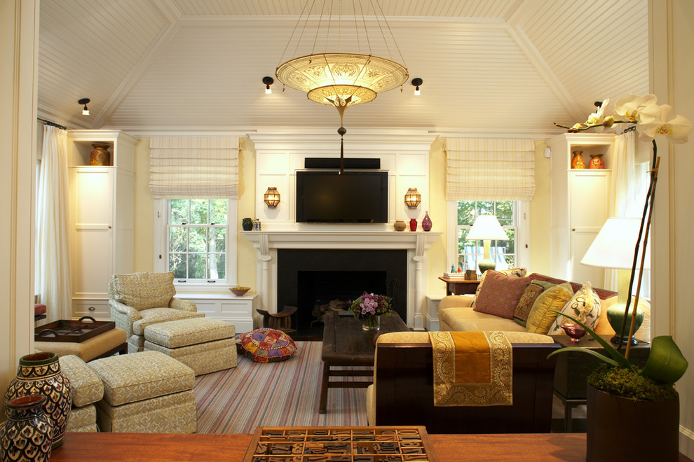 Immagine di un soggiorno minimal con pareti beige, camino classico e TV a parete