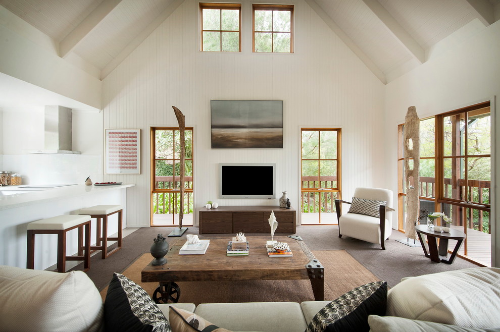 Immagine di un soggiorno minimal di medie dimensioni con pareti bianche, moquette e TV a parete