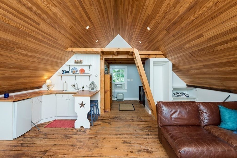 Inspiration för små lantliga allrum på loftet, med ljust trägolv och beiget golv