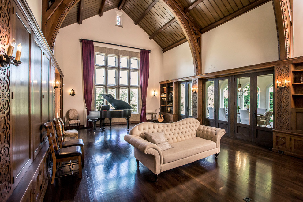Imagen de sala de estar con rincón musical clásica con paredes beige, suelo de madera oscura y suelo marrón