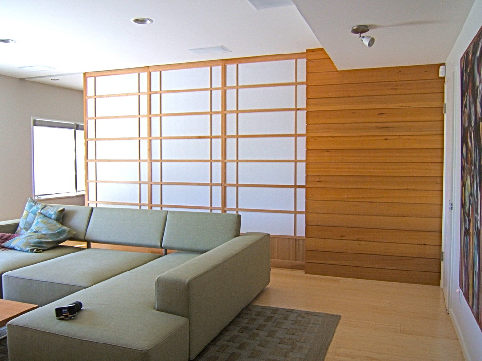 На фото: гостиная комната в современном стиле с полом из бамбука и скрытым телевизором