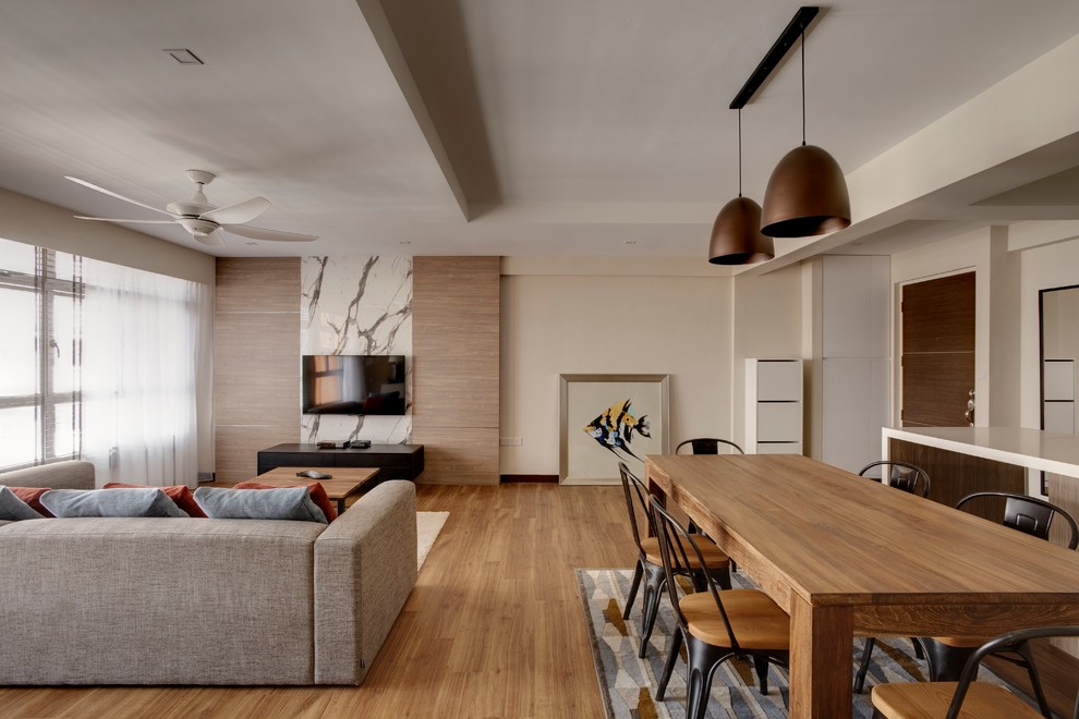 Diseño de sala de estar abierta escandinava pequeña con paredes beige, suelo de madera en tonos medios y televisor colgado en la pared