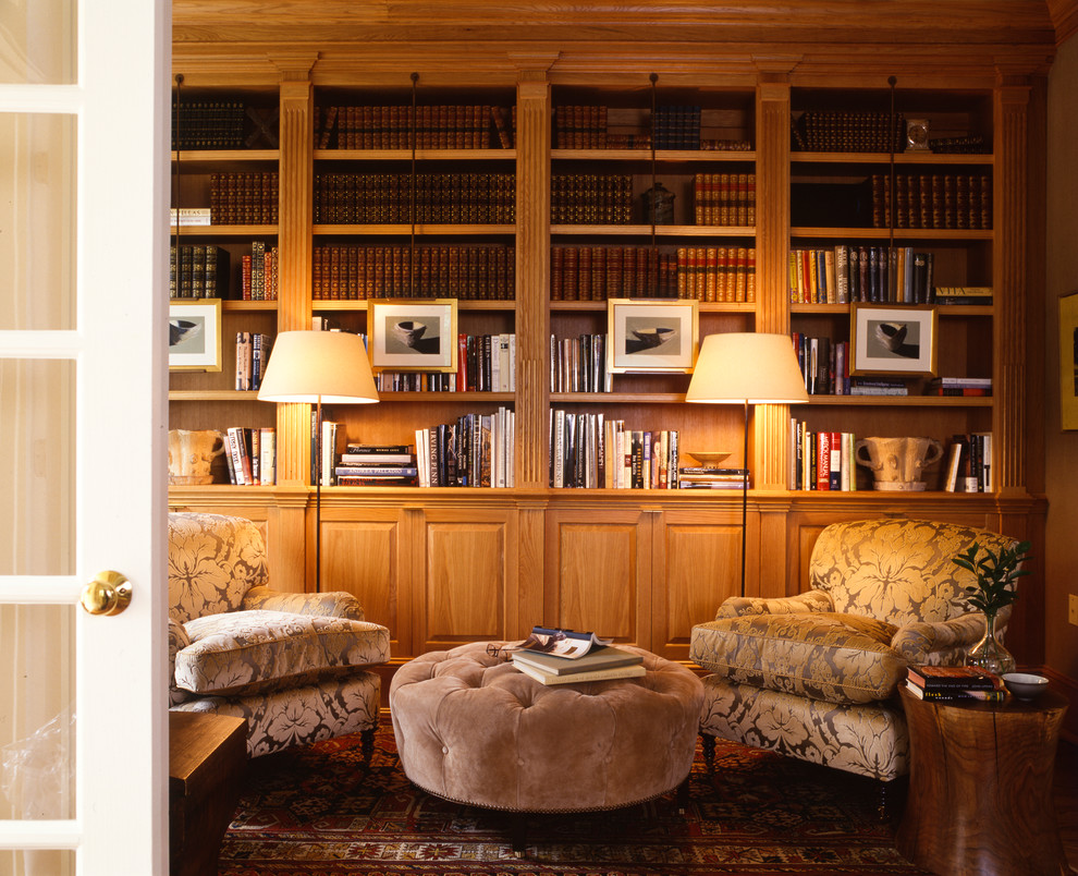 Ejemplo de sala de estar con biblioteca cerrada clásica renovada de tamaño medio sin chimenea y televisor con paredes marrones y suelo de madera en tonos medios