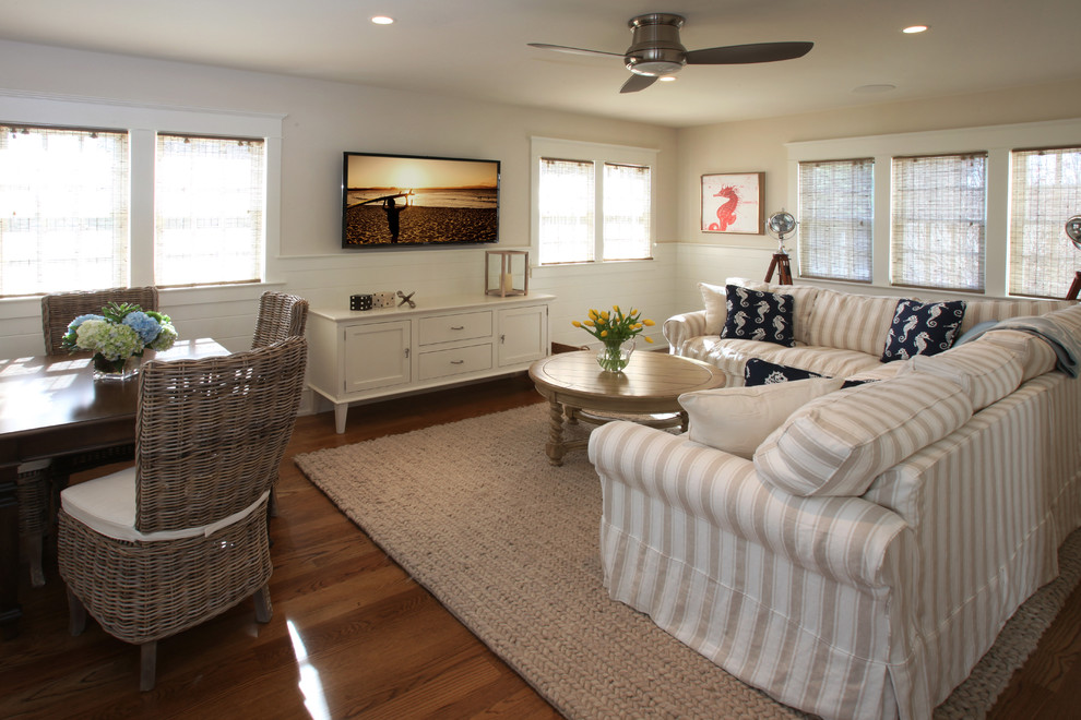 Foto de sala de estar abierta clásica de tamaño medio con paredes beige, suelo de madera clara y televisor colgado en la pared