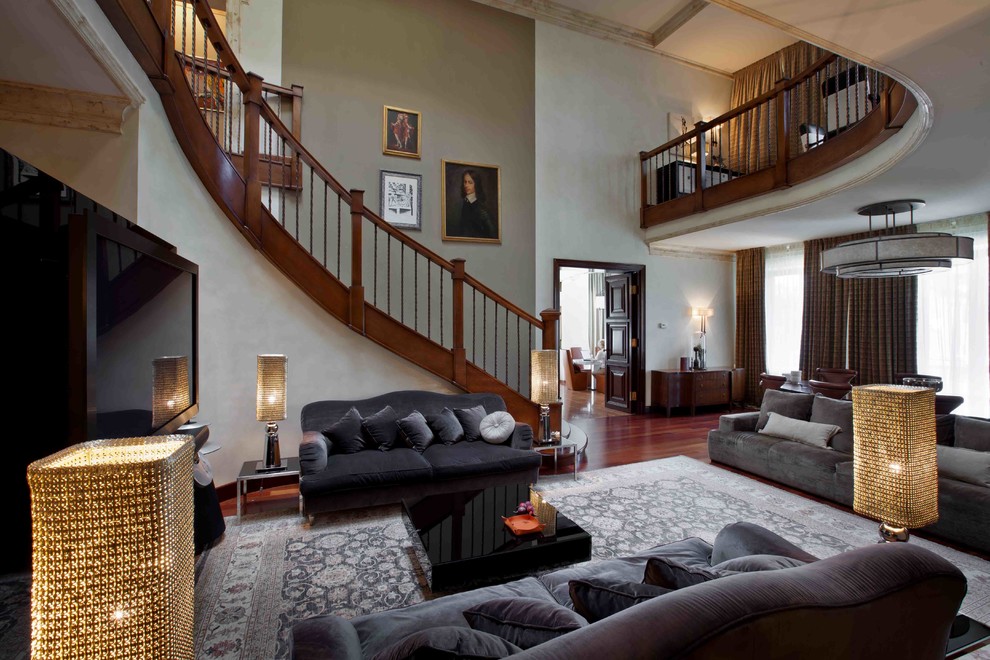 Photo of a medium sized classic mezzanine games room in Other with a home bar, grey walls, dark hardwood flooring, a standard fireplace, a stone fireplace surround, a freestanding tv and red floors.