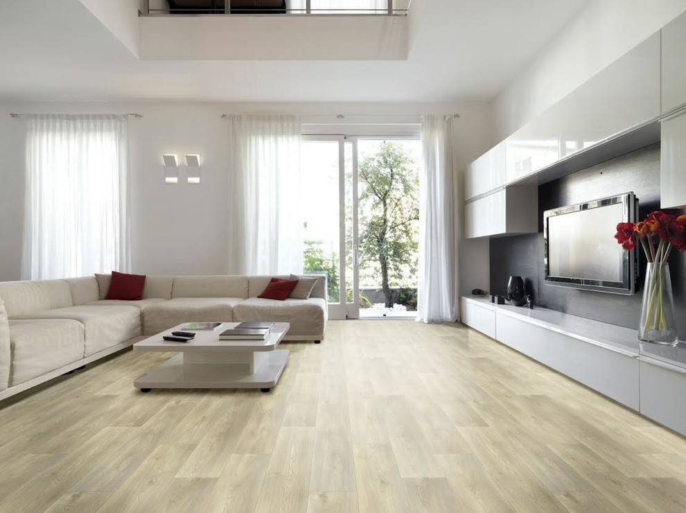 Diseño de sala de estar moderna extra grande sin chimenea con paredes blancas, suelo de madera clara, televisor colgado en la pared y suelo marrón