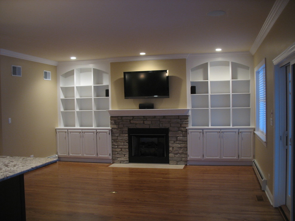 This is an example of a medium sized classic enclosed games room in Chicago with yellow walls, medium hardwood flooring, a standard fireplace and a wall mounted tv.