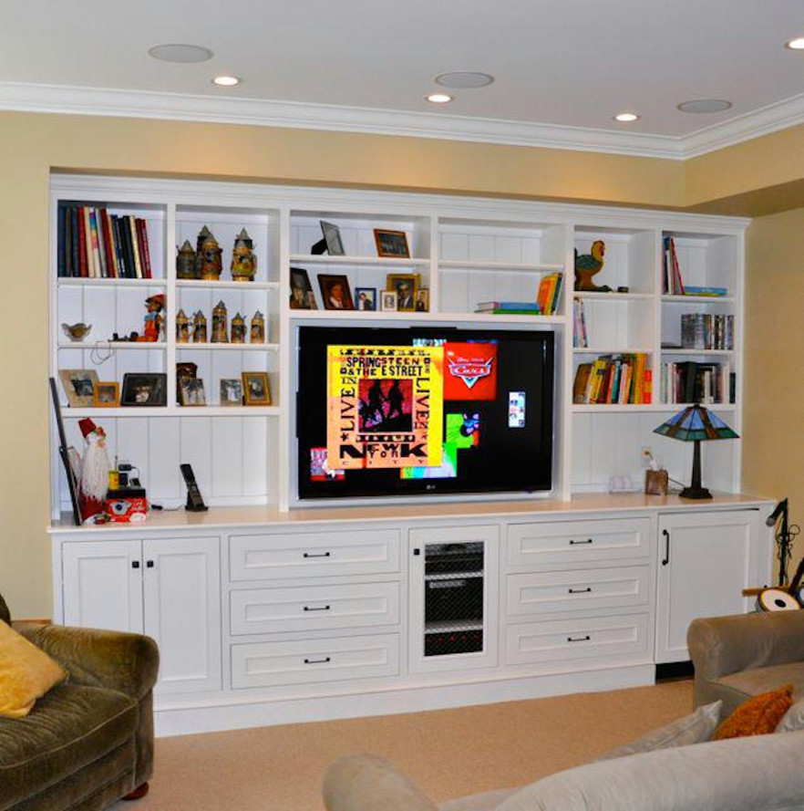 Réalisation d'une salle de séjour tradition avec un mur beige, moquette et un téléviseur encastré.
