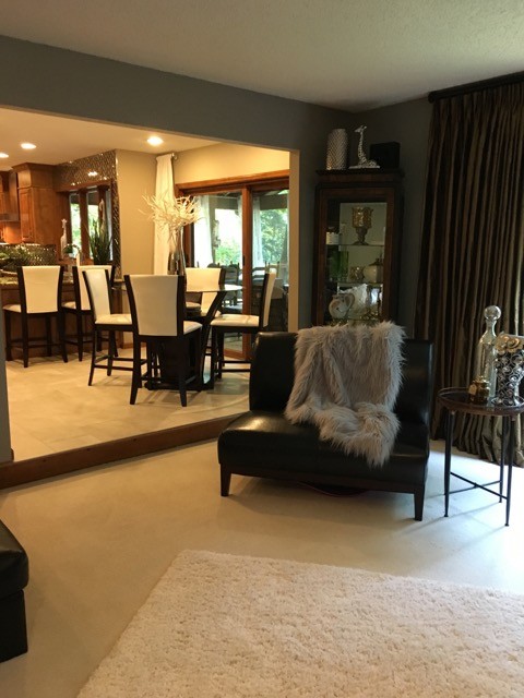 Ejemplo de sala de estar abierta contemporánea de tamaño medio con paredes grises, moqueta, todas las chimeneas, marco de chimenea de ladrillo, televisor independiente y suelo beige