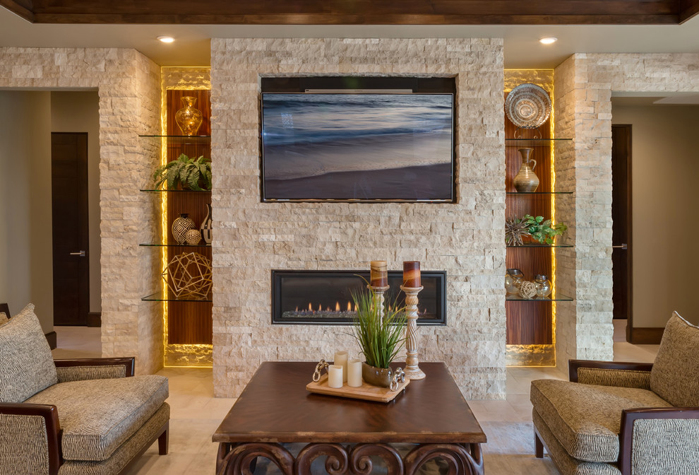 На фото: открытая гостиная комната среднего размера в морском стиле с домашним баром, бежевыми стенами, полом из травертина, горизонтальным камином, фасадом камина из камня и телевизором на стене с
