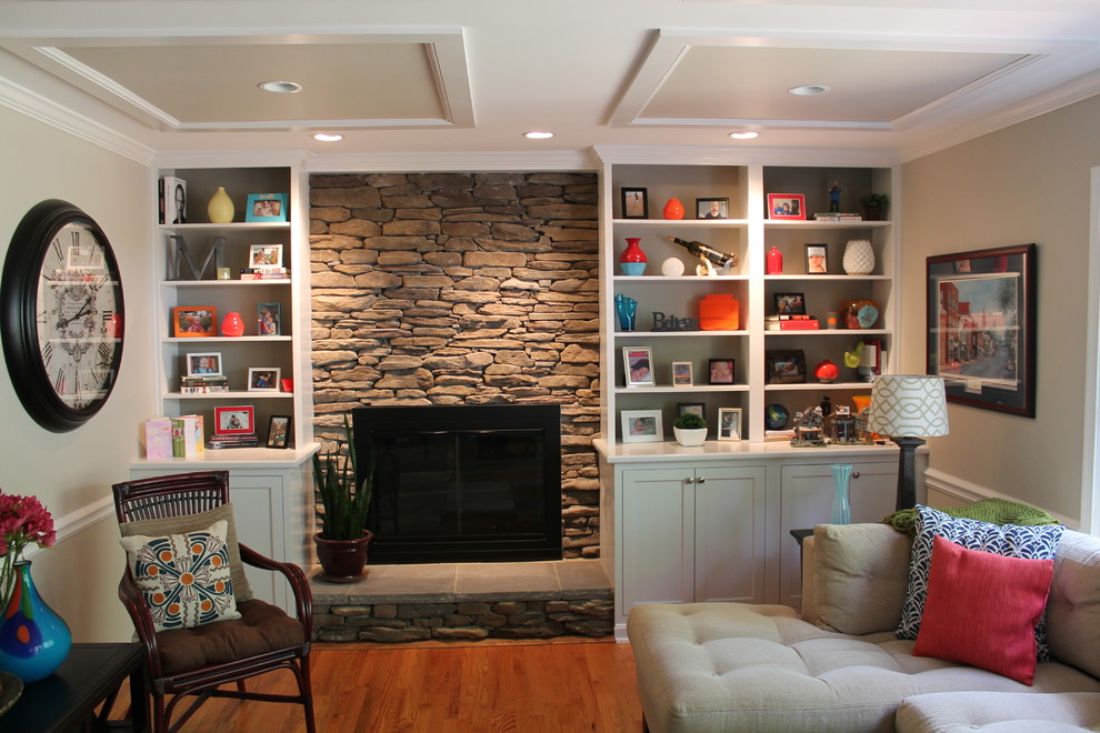 Inspiration for a mid-sized eclectic open concept medium tone wood floor family room remodel in DC Metro with beige walls, a standard fireplace, a stone fireplace and a wall-mounted tv