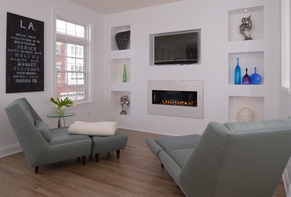 Exemple d'une salle de séjour tendance ouverte avec un mur blanc, parquet clair, une cheminée standard, un manteau de cheminée en plâtre et un téléviseur encastré.