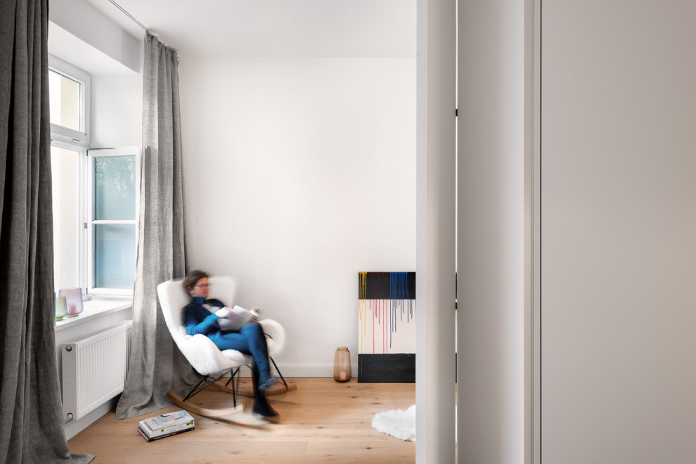 Ejemplo de sala de estar abierta actual pequeña con paredes blancas y suelo de madera clara