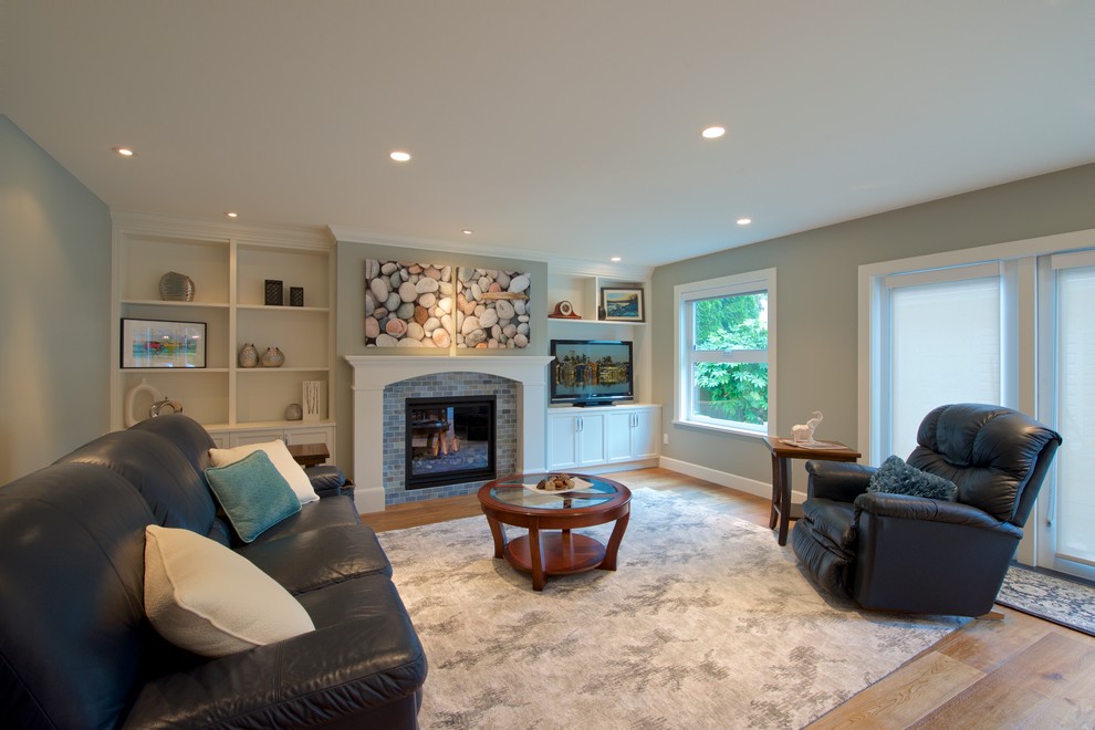 Diseño de sala de estar abierta clásica renovada de tamaño medio con suelo de madera en tonos medios, todas las chimeneas, marco de chimenea de madera, televisor independiente y paredes azules