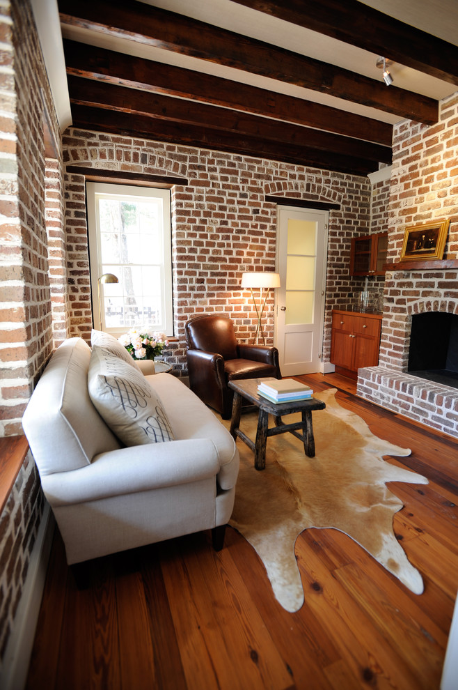 Diseño de sala de estar actual con suelo de madera en tonos medios, todas las chimeneas y marco de chimenea de ladrillo