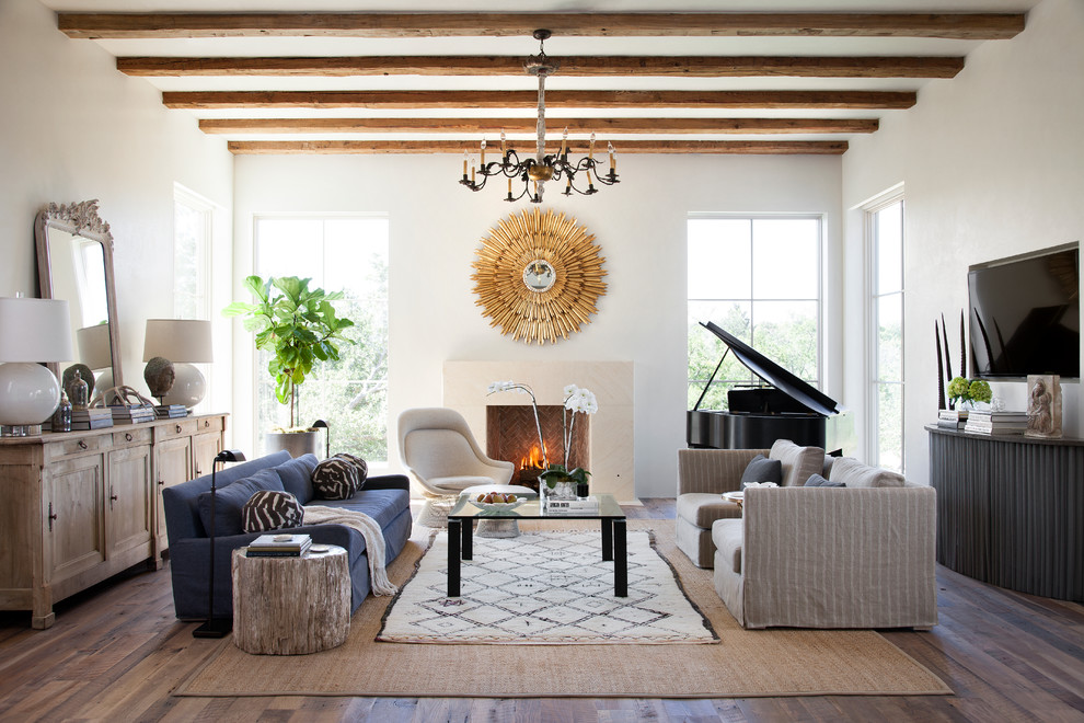 Mediterranean enclosed living room in Austin with white walls, dark hardwood flooring, a standard fireplace and a wall mounted tv.