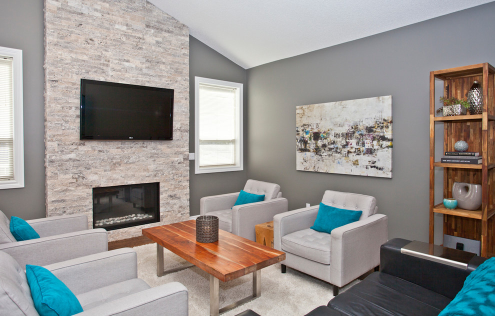 Example of a mid-sized trendy open concept medium tone wood floor family room design in Calgary with gray walls, a standard fireplace, a stone fireplace and a wall-mounted tv