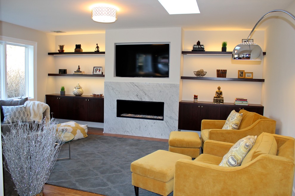 На фото: открытая гостиная комната среднего размера в стиле модернизм с серыми стенами, паркетным полом среднего тона, горизонтальным камином, фасадом камина из камня, телевизором на стене и ковром на полу