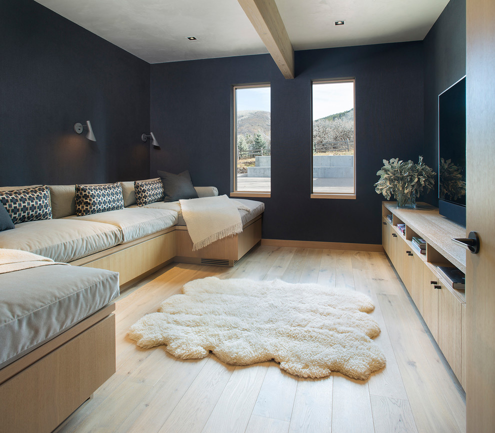 Bild på ett funkis avskilt allrum, med blå väggar, ljust trägolv, en fristående TV och beiget golv