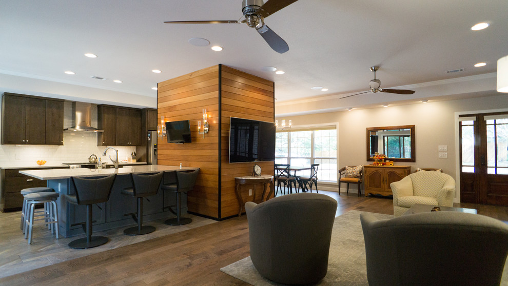 Mittelgroßes, Offenes Modernes Wohnzimmer mit grauer Wandfarbe, braunem Holzboden, Kamin, gefliester Kaminumrandung und TV-Wand in Austin