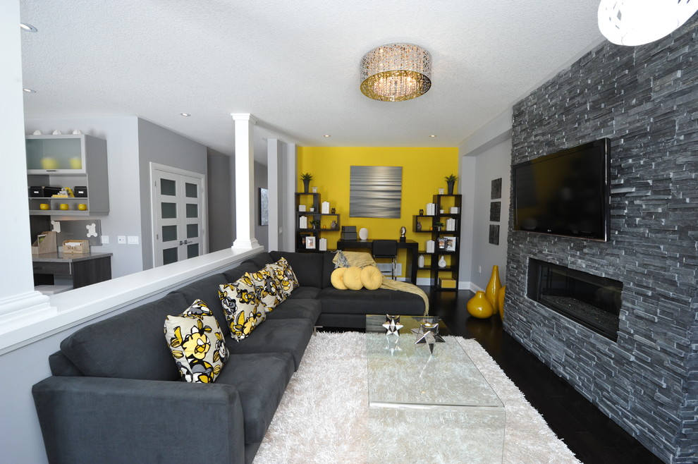 Mittelgroßes, Offenes Modernes Wohnzimmer mit grauer Wandfarbe, dunklem Holzboden, Kamin, Kaminumrandung aus Stein, TV-Wand und braunem Boden in Toronto