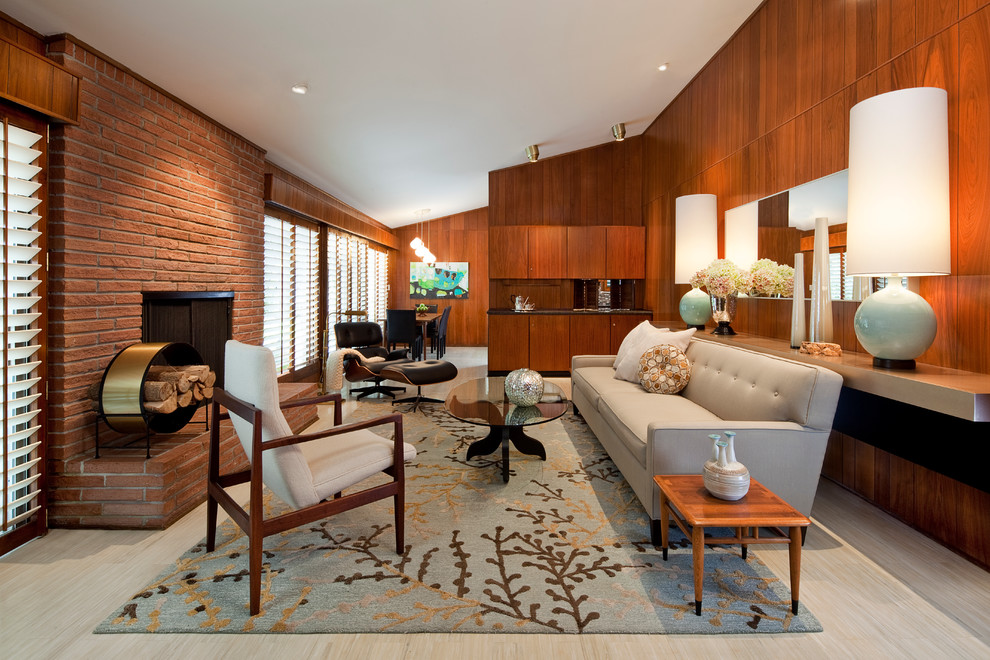 На фото: большая открытая гостиная комната в стиле ретро с коричневыми стенами, полом из линолеума, стандартным камином и фасадом камина из кирпича