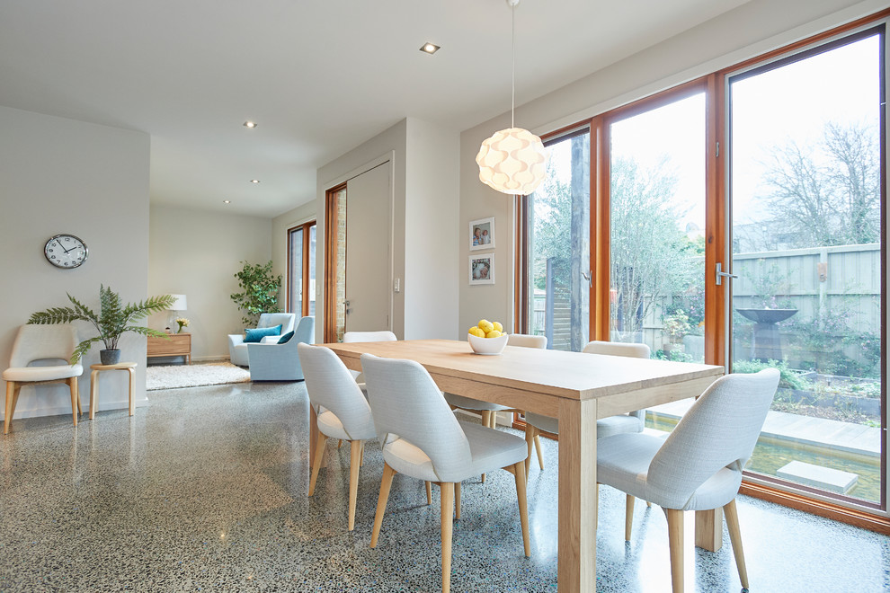 Inspiration för mellanstora minimalistiska matplatser, med vita väggar, betonggolv och grått golv