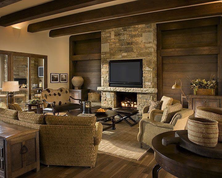 Exemple d'une grande salle de séjour montagne ouverte avec un mur beige, parquet clair, une cheminée standard, un manteau de cheminée en pierre et un téléviseur fixé au mur.