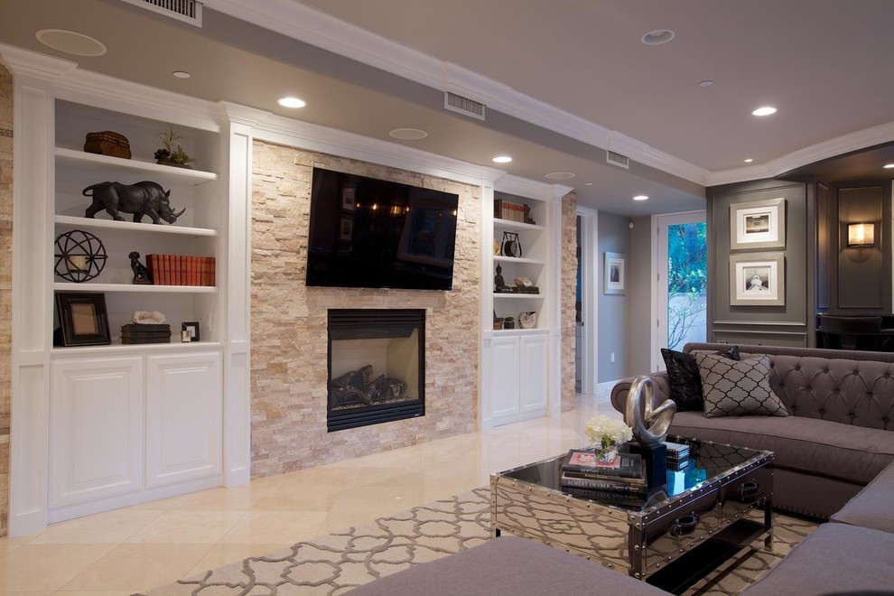 Modern inredning av ett stort allrum med öppen planlösning, med en hemmabar, beige väggar, kalkstensgolv och en väggmonterad TV