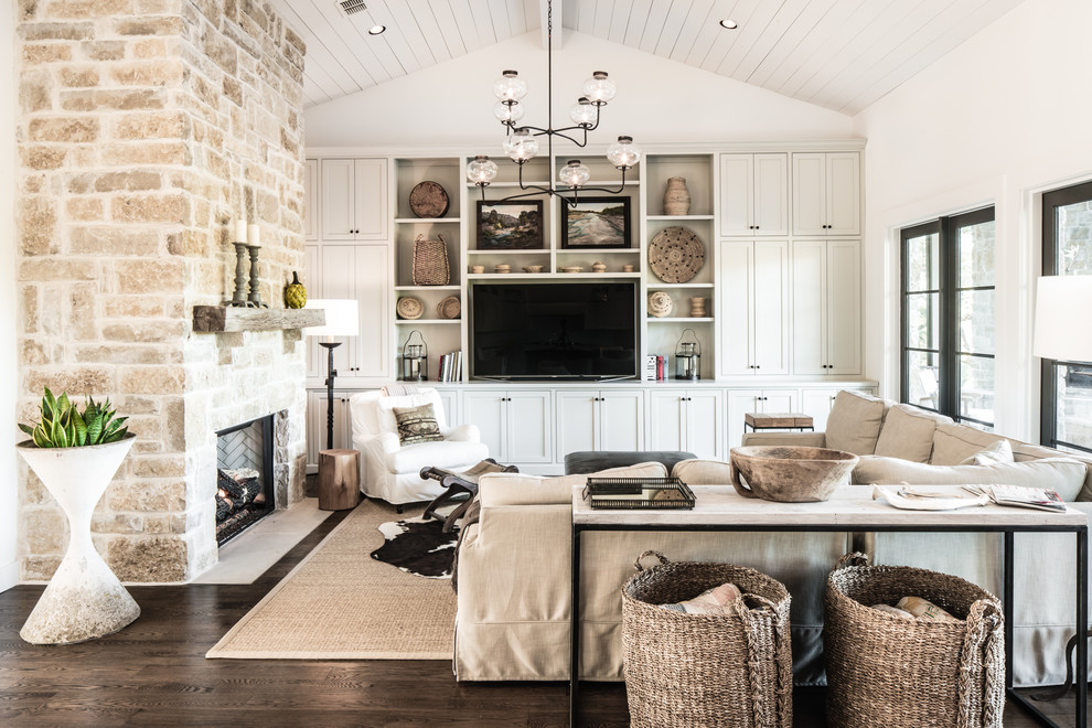 Klassisches Wohnzimmer mit weißer Wandfarbe, dunklem Holzboden, Kamin, Multimediawand und Kaminumrandung aus Stein in Austin