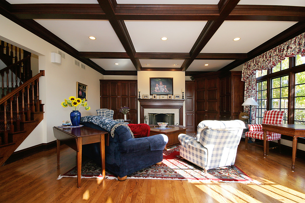 Inspiration pour une grande salle de séjour traditionnelle ouverte avec un mur beige, un sol en bois brun, une cheminée standard, un manteau de cheminée en carrelage et un téléviseur encastré.