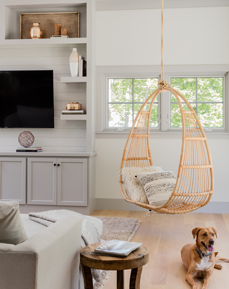 Photo of an expansive country open plan games room in Boston with white walls, a wall mounted tv, medium hardwood flooring and brown floors.