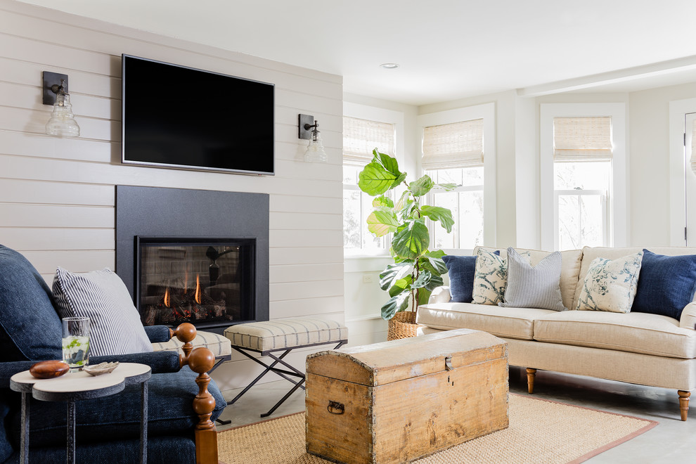 Источник вдохновения для домашнего уюта: гостиная комната в морском стиле с бежевыми стенами, бетонным полом и телевизором на стене