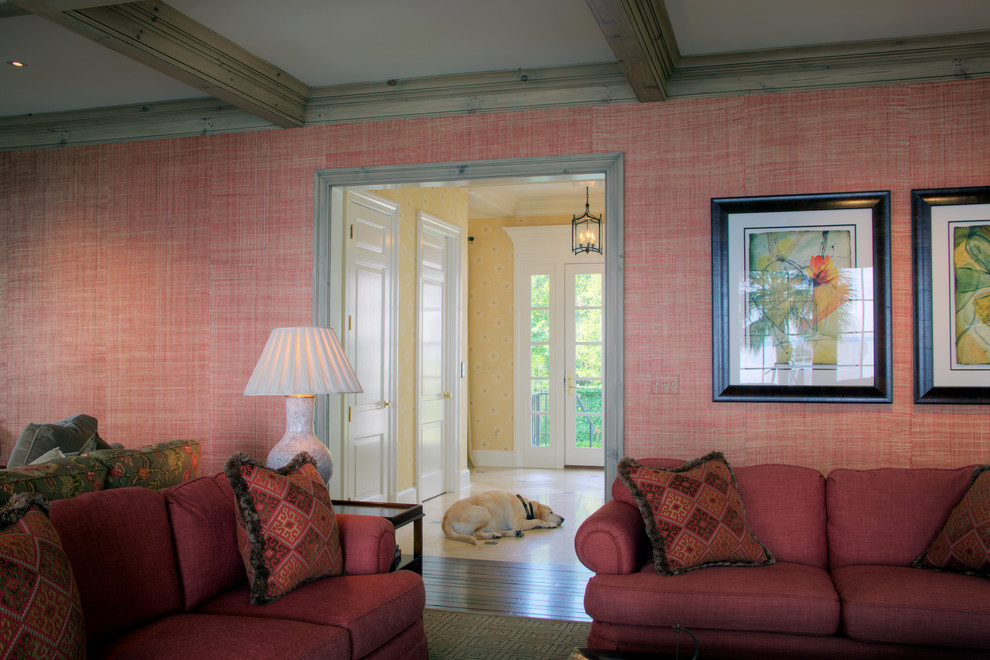 Diseño de sala de estar cerrada clásica grande con paredes rosas, suelo de madera oscura, todas las chimeneas, marco de chimenea de piedra y pared multimedia