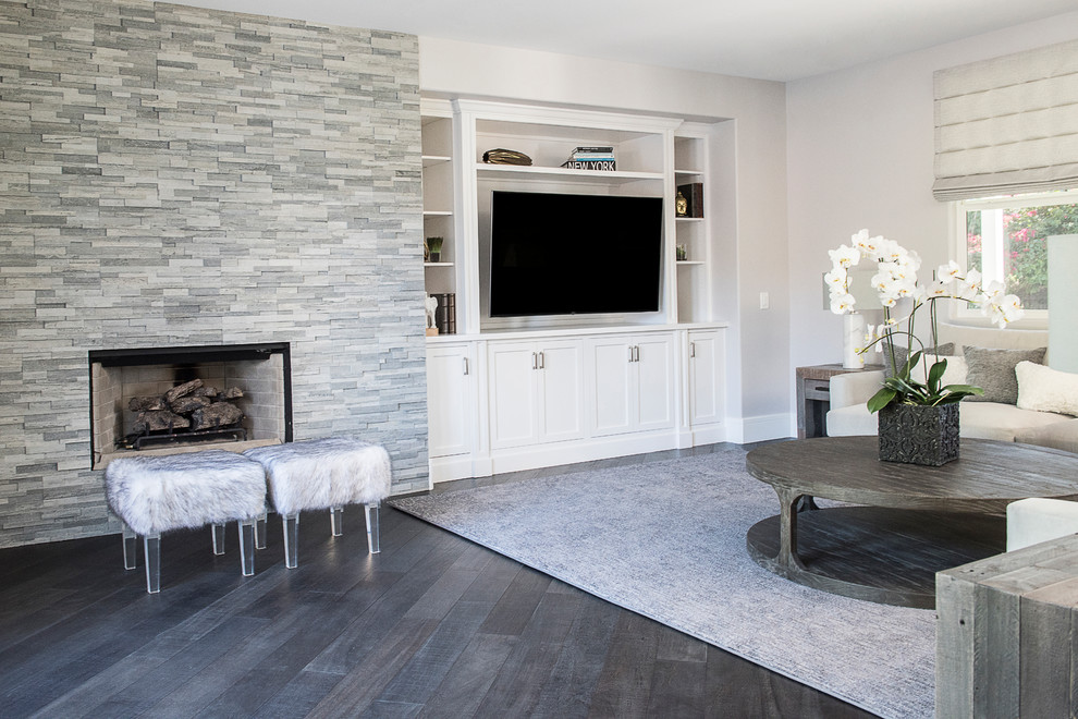 Foto de sala de estar abierta contemporánea de tamaño medio con paredes grises, suelo de madera oscura, todas las chimeneas, marco de chimenea de piedra, pared multimedia, suelo marrón y alfombra