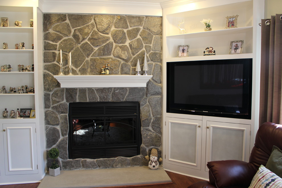 Elegant family room photo in New York with a standard fireplace, a stone fireplace and a media wall