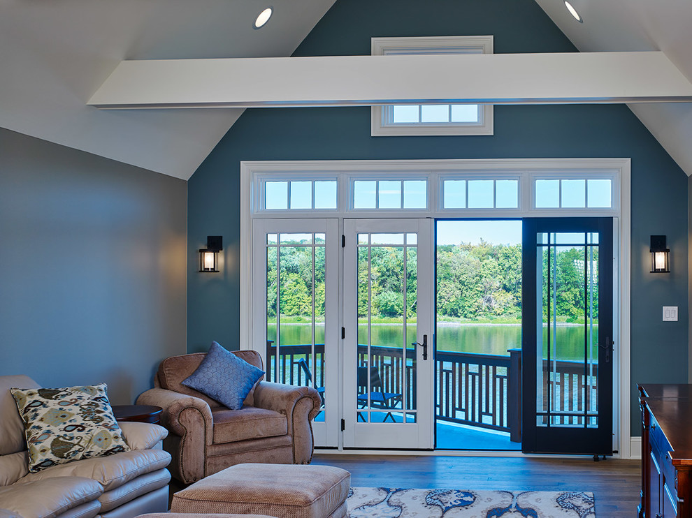 Esempio di un grande soggiorno stile loft con libreria, pareti blu, pavimento in legno massello medio e TV autoportante