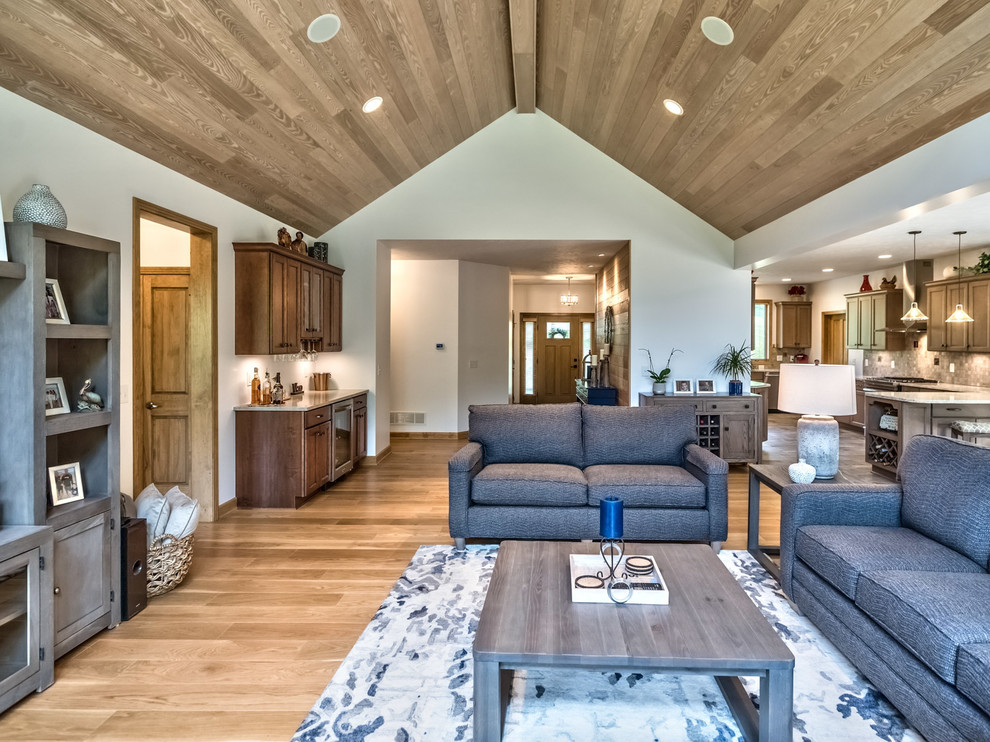 Foto de sala de estar con barra de bar abierta rústica de tamaño medio con televisor independiente, paredes blancas, suelo de madera clara y suelo marrón