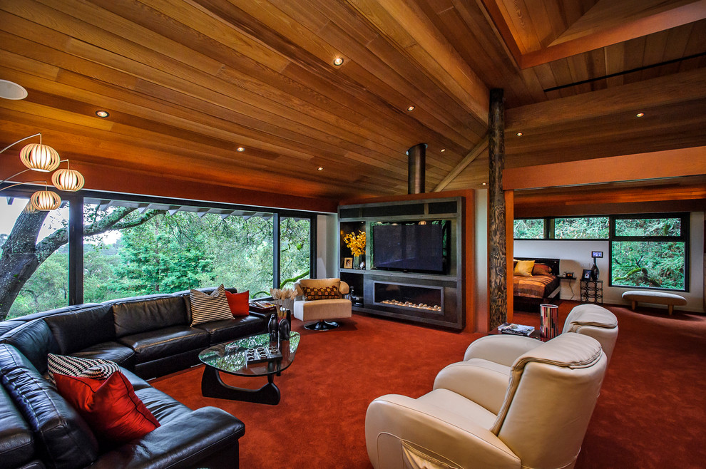 Ejemplo de sala de estar tipo loft minimalista grande con paredes rojas, moqueta, chimenea lineal y pared multimedia